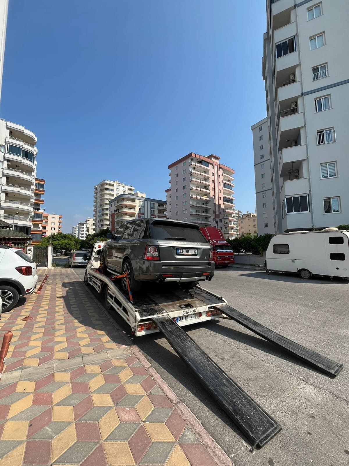 Rampaları açılmış kayar kasa çekiciye arazi aracının yüklenmesi
