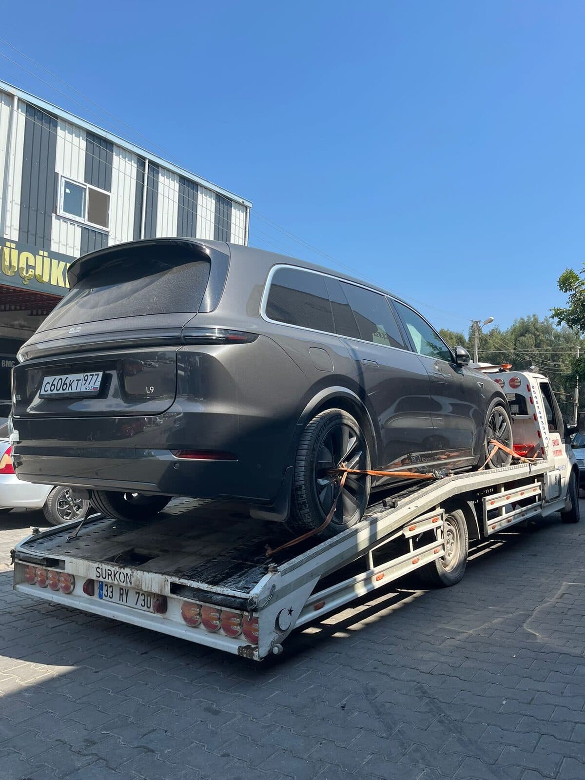 Çekici platformuna alınmış SUV'un tekerlekleri kayışlarla sabitlenmiş halde